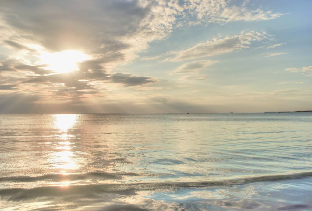 Light shining through clouds and over the waters