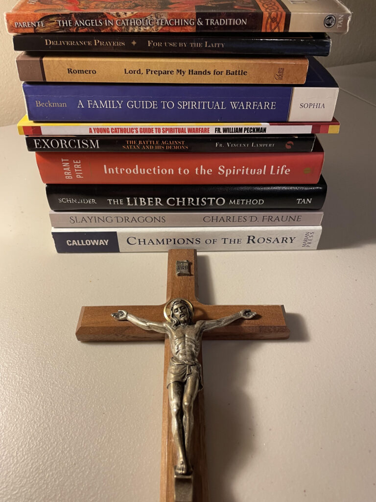 10 of the best spiritual warfare books of the Catholic Church with a holy crucifix